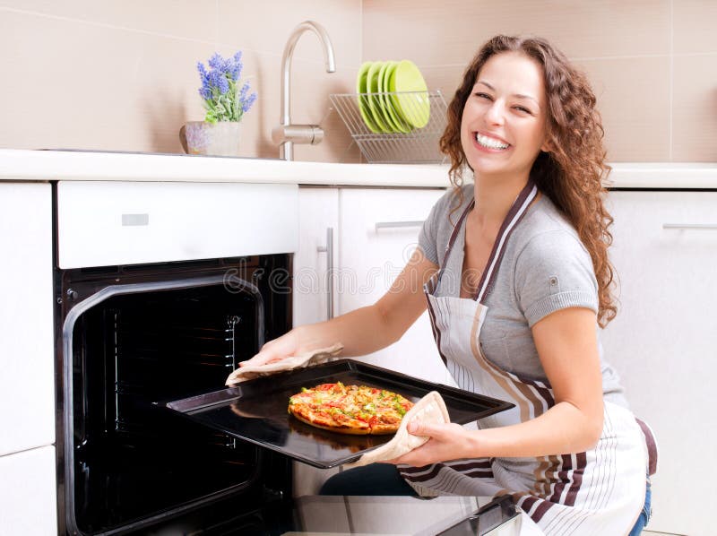 Mulher nova que cozinha a pizza fotos de stock royalty free Mulher nova que cozinha a pizza fotos de stock royalty free