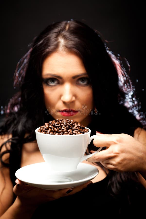 Mulher nova que prende uma chávena de café fotografia de stock