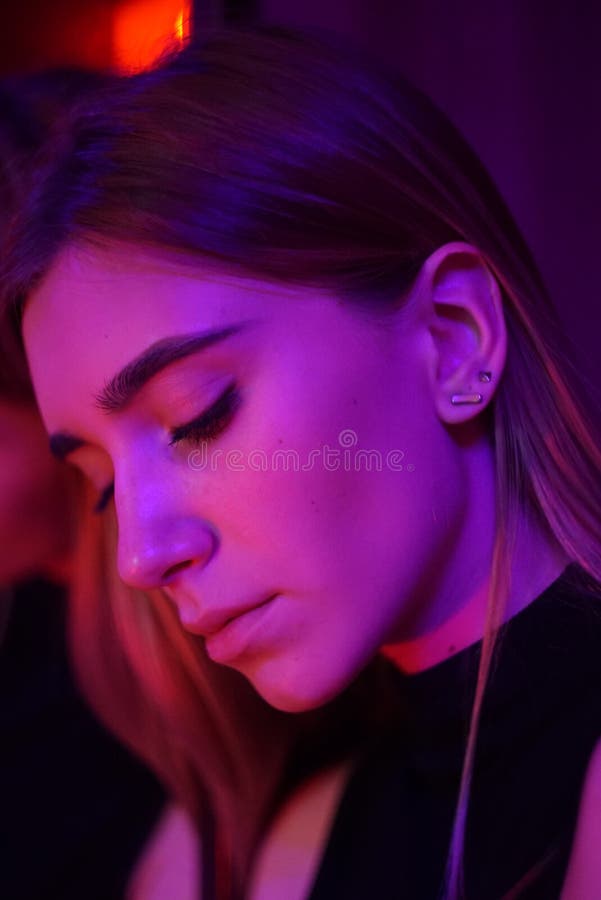 Mulher nova 'sexy' da beleza que levanta sobre o fundo de néon vermelho da cidade da noite e azul dramático fotos de stock Mulher nova 'sexy' da beleza que levanta sobre o fundo de néon vermelho da cidade da noite e azul dramático fotos de stock