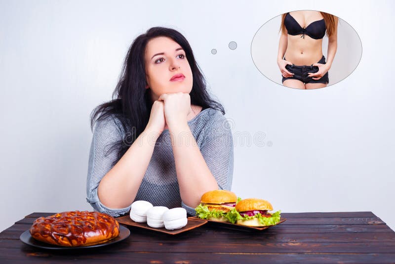 Mulher obeso excesso de peso com comida lixo que sonha do ajuste e de b magro fotografia de stock royalty free Mulher obeso excesso de peso com comida lixo que sonha do ajuste e de b magro fotografia de stock royalty free