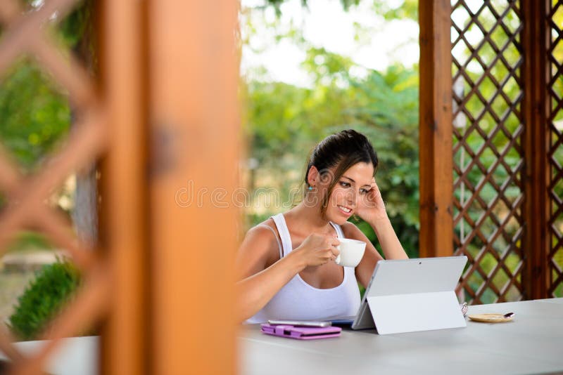 Mulher ocasional profissional que trabalha em linha com portátil fora fotografia de stock Mulher ocasional profissional que trabalha em linha com portátil fora fotografia de stock