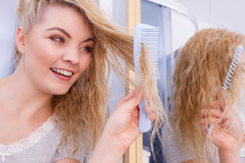 Mulher penteando seu cabelo longo no banheiro foto de stock
