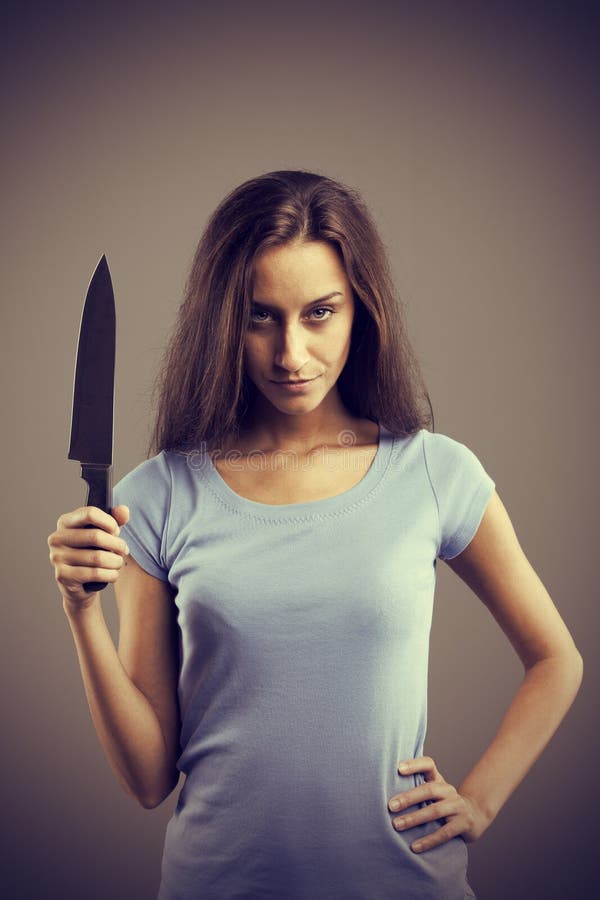 Unsettling dark young woman holding a dengerous knife in his hand. Unsettling dark young woman holding a dengerous knife in his hand