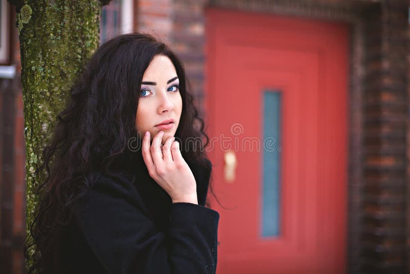 Mulher perto da porta de entrada vermelha na rua imagens de stock royalty free Mulher perto da porta de entrada vermelha na rua imagens de stock royalty free