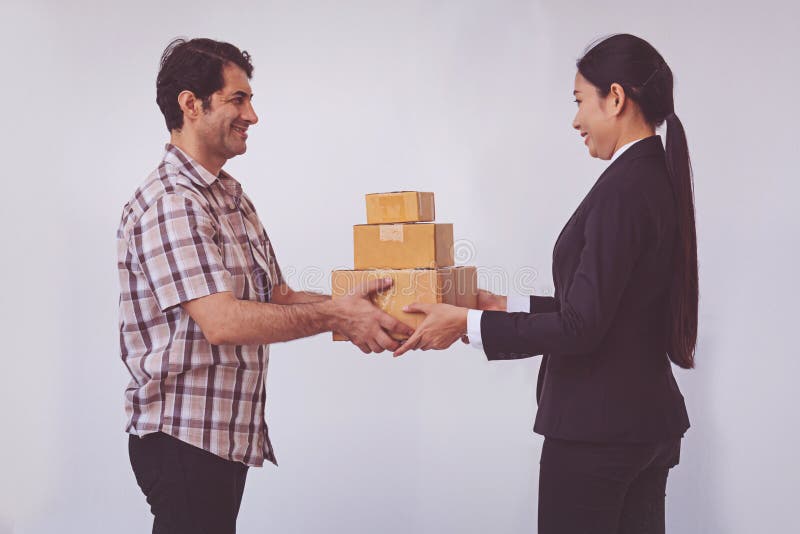 A mulher que aceita recebe uma entrega das caixas do homem do asi?tico da entrega imagens de stock A mulher que aceita recebe uma entrega das caixas do homem do asi?tico da entrega imagens de stock