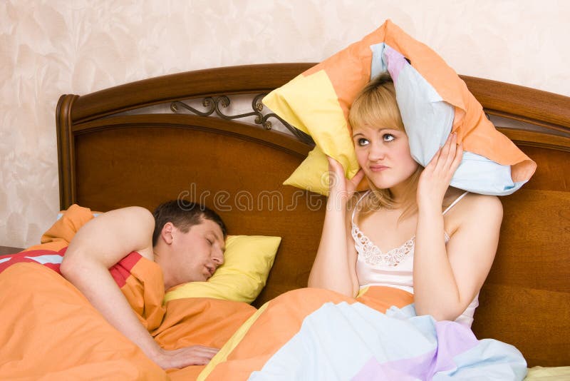 Mulher que acorda por seu marido que ressona fotografia de stock royalty free Mulher que acorda por seu marido que ressona fotografia de stock royalty free