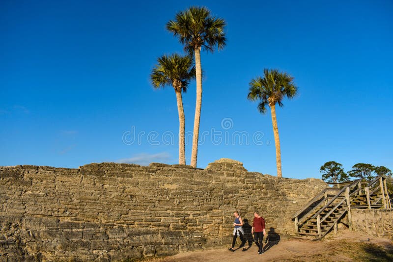 Mulher que anda na área de Castillo de San Marcos Fort na costa histórica de Florida imagens de stock Mulher que anda na área de Castillo de San Marcos Fort na costa histórica de Florida imagens de stock