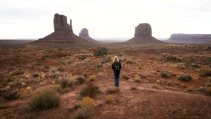 A mulher que anda no vale do monumento com vermelho balança a vista geral