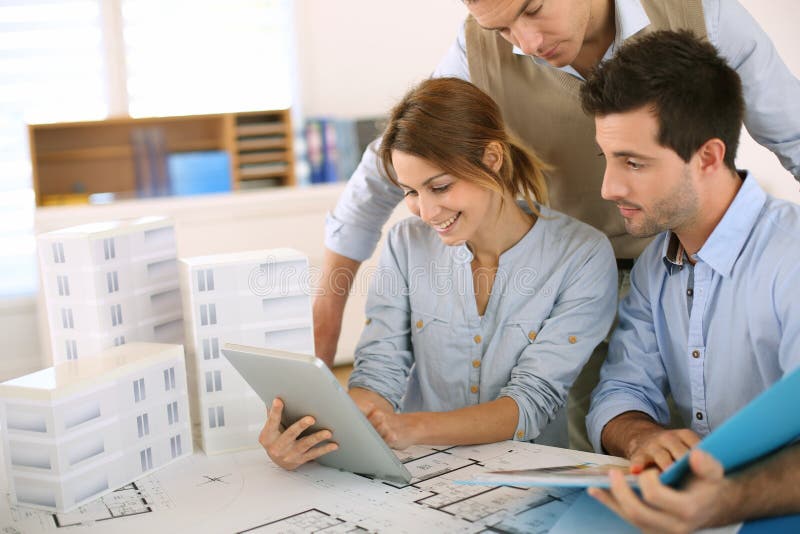 Mulher que apresenta o projeto aos arquitetos foto de stock Mulher que apresenta o projeto aos arquitetos foto de stock