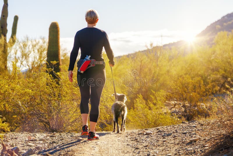 Mulher que caminha com o cão em Phoenix o Arizona