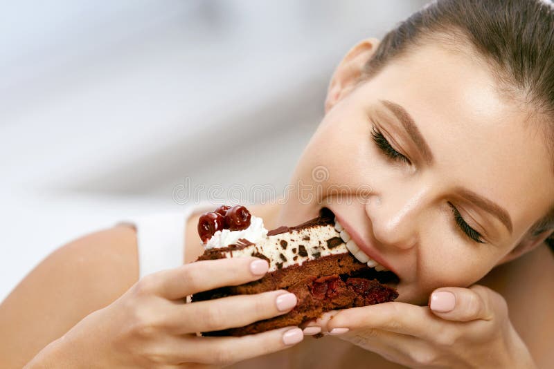 Mulher que come o bolo Sobremesa fêmea bonita comer