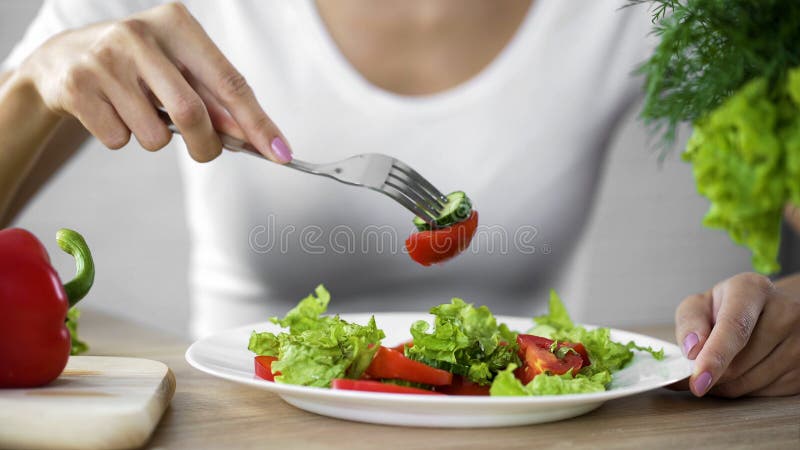 Mulher que come a salada vegetal, observando a dieta e contando calorias, bem-estar fotografia de stock Mulher que come a salada vegetal, observando a dieta e contando calorias, bem-estar fotografia de stock