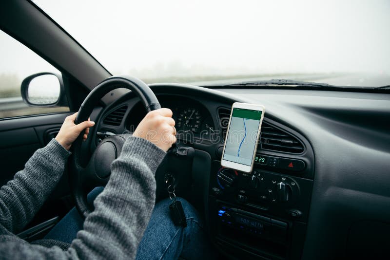 Mulher que conduz o carro pela estrada no tempo nevoento imagem de stock Mulher que conduz o carro pela estrada no tempo nevoento imagem de stock