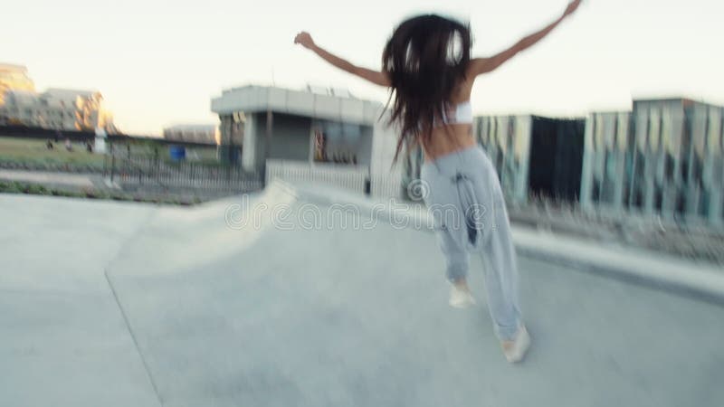 Mulher que corre em torno de um parque do patim