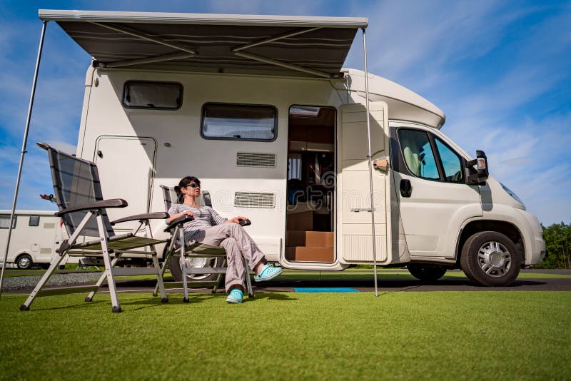 Mulher que descansa perto dos motorhomes na natureza Curso das férias em família, fotos de stock Mulher que descansa perto dos motorhomes na natureza Curso das férias em família, fotos de stock
