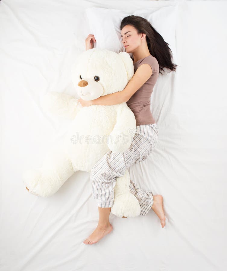 Mulher a dormir com um urso de peluche grande fotos de stock royalty free
