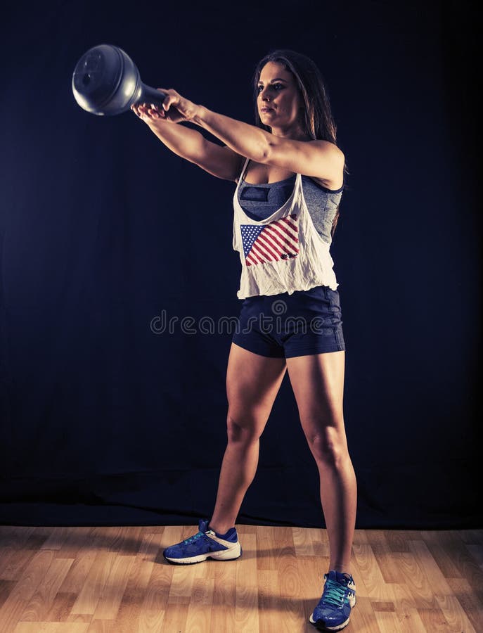 Mulher que faz balanços do kettlebell fotografia de stock royalty free Mulher que faz balanços do kettlebell fotografia de stock royalty free