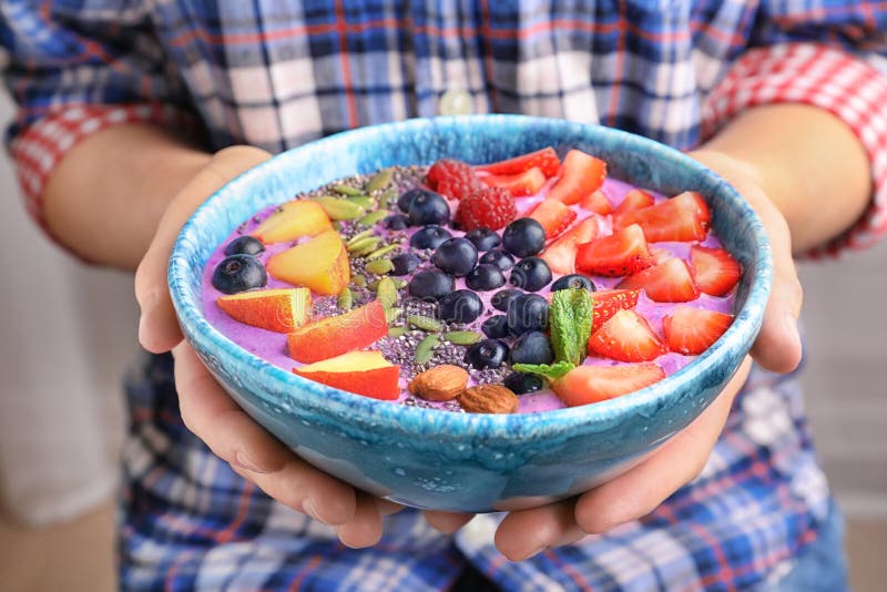Mulher que guarda a bacia com o batido delicioso FO do acai imagens de stock Mulher que guarda a bacia com o batido delicioso FO do acai imagens de stock