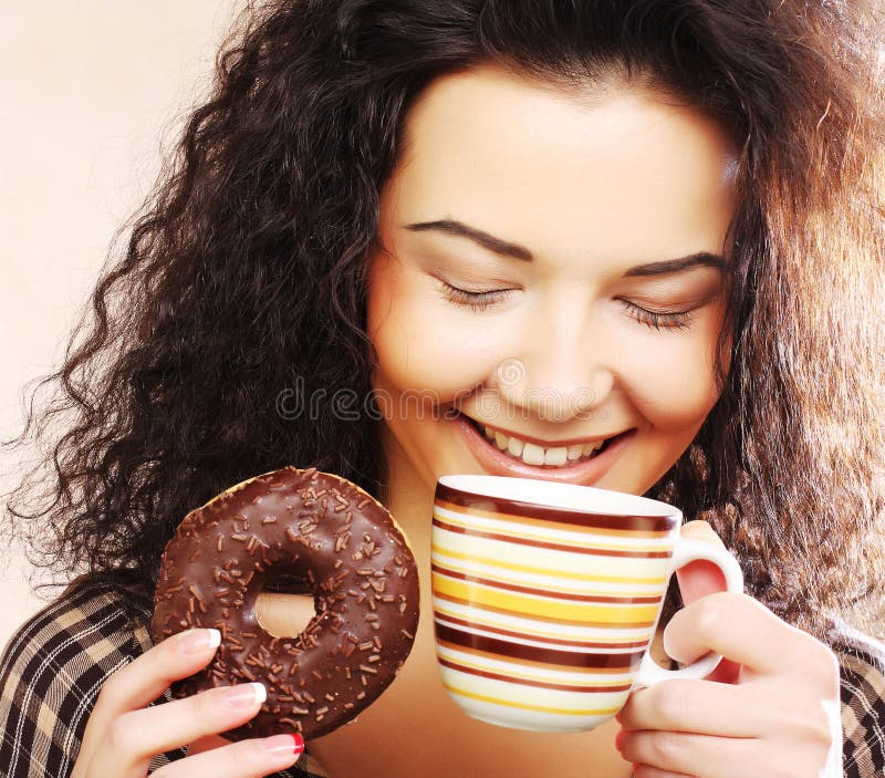 Mulher a segurar um donut e café fotografia de stock royalty free