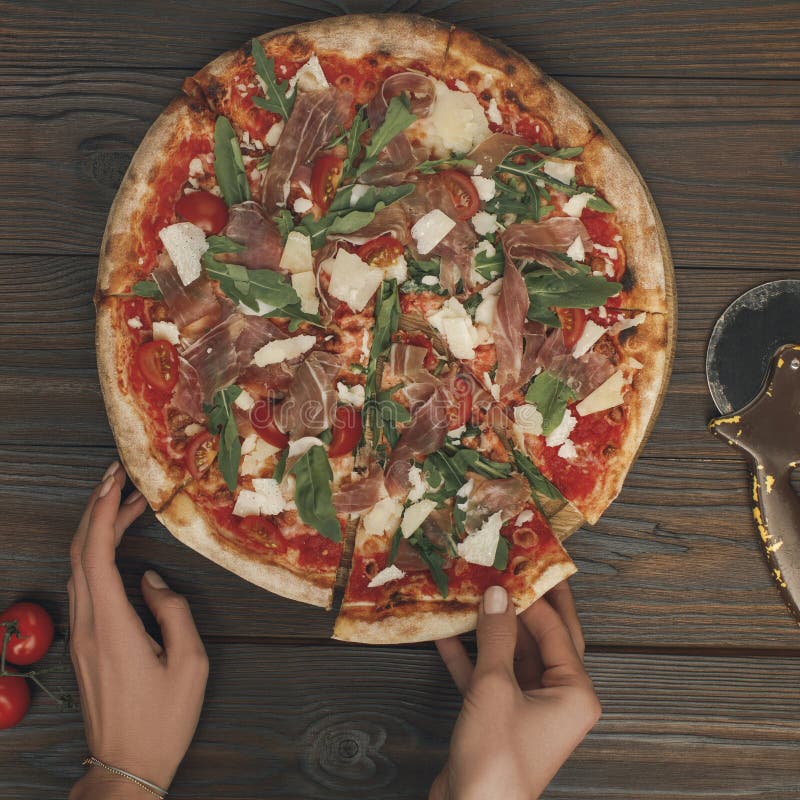 Mulher que guarda a parte de pizza italiana imagens de stock Mulher que guarda a parte de pizza italiana imagens de stock