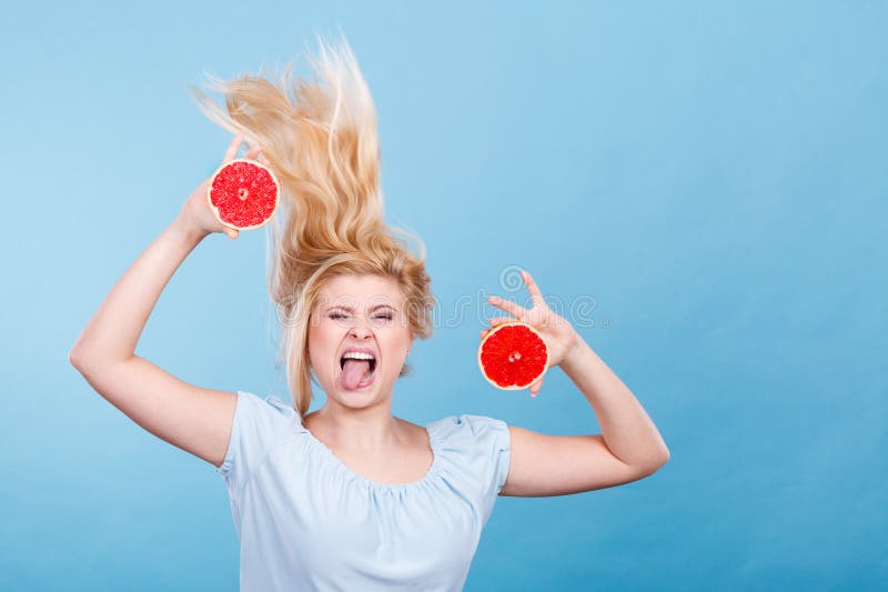 Mulher que guarda a toranja vermelha que tem o cabelo windblown louco imagens de stock royalty free Mulher que guarda a toranja vermelha que tem o cabelo windblown louco imagens de stock royalty free