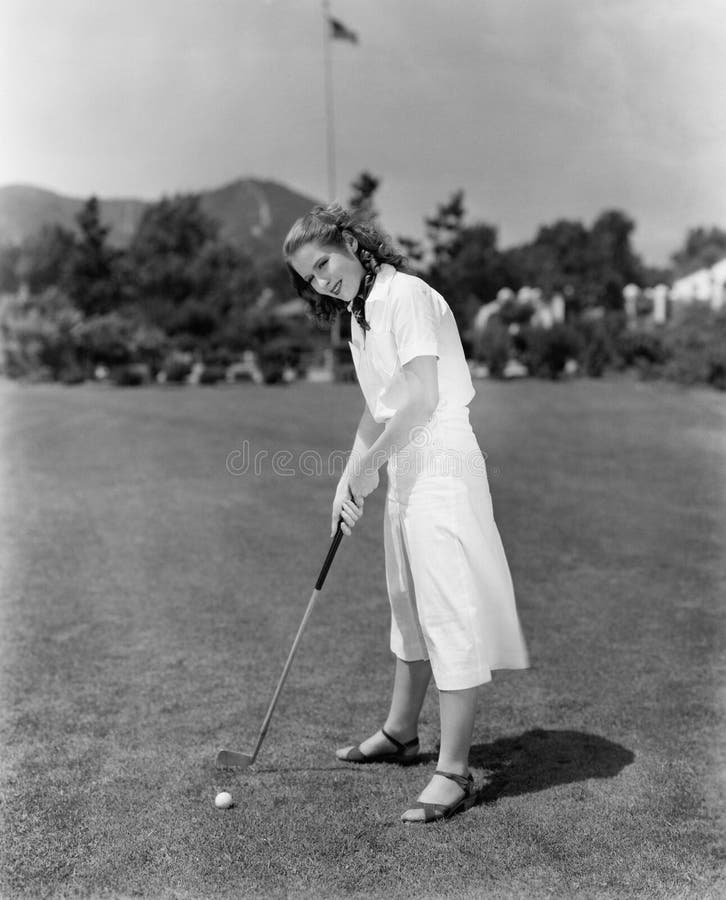Mulher que joga o golfe em um campo de golfe (todas as pessoas descritas não são umas vivas mais longo e nenhuma propriedade exis imagem de stock royalty free Mulher que joga o golfe em um campo de golfe (todas as pessoas descritas não são umas vivas mais longo e nenhuma propriedade exis imagem de stock royalty free