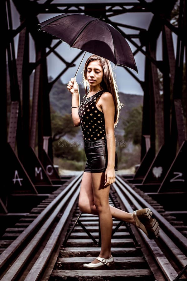 Mulher que levanta em trilhas de estrada de ferro fotografia de stock Mulher que levanta em trilhas de estrada de ferro fotografia de stock