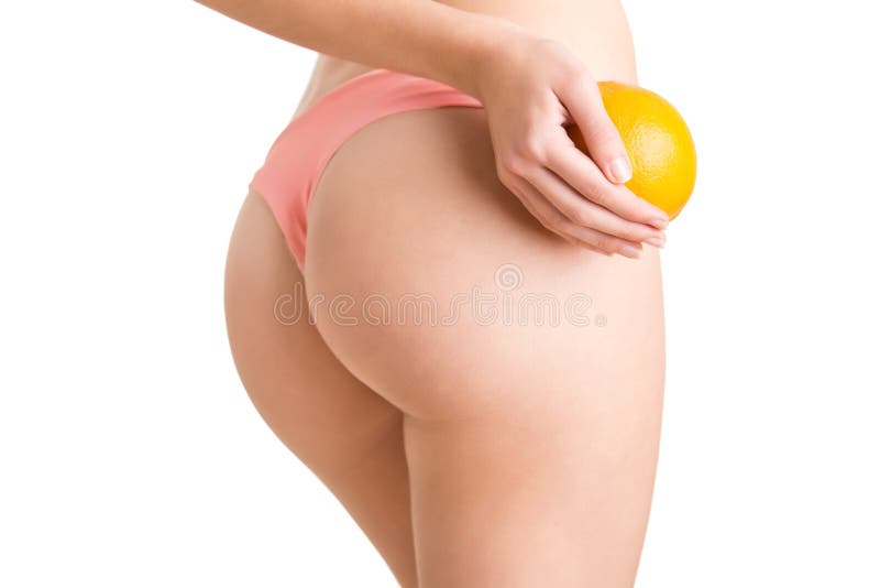 Mulher que mantém uma laranja contra suas coxas