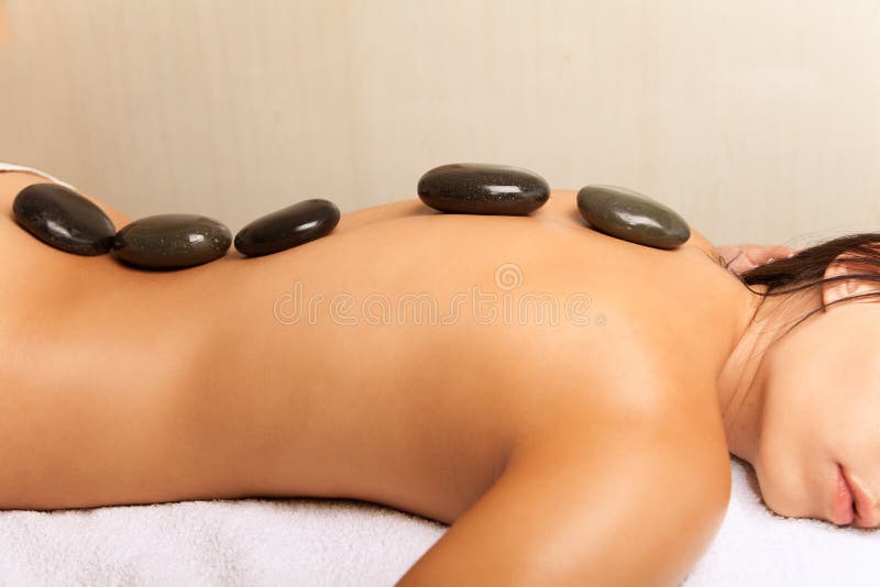 Mulher que obtem uma massagem de pedra quente no salão de beleza dos termas imagens de stock Mulher que obtem uma massagem de pedra quente no salão de beleza dos termas imagens de stock