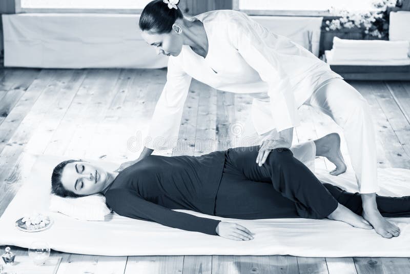 Mulher que obtém a massagem de esticão tailandesa tradicional pelo terapeuta fotos de stock Mulher que obtém a massagem de esticão tailandesa tradicional pelo terapeuta fotos de stock