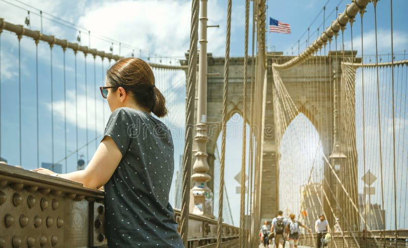 Mulher que olha a arquitetura da cidade da ponte de Brooklyn em New York City imagens de stock Mulher que olha a arquitetura da cidade da ponte de Brooklyn em New York City imagens de stock