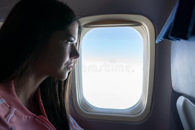 Mulher que olha através da janela no avião fotos de stock Mulher que olha através da janela no avião fotos de stock