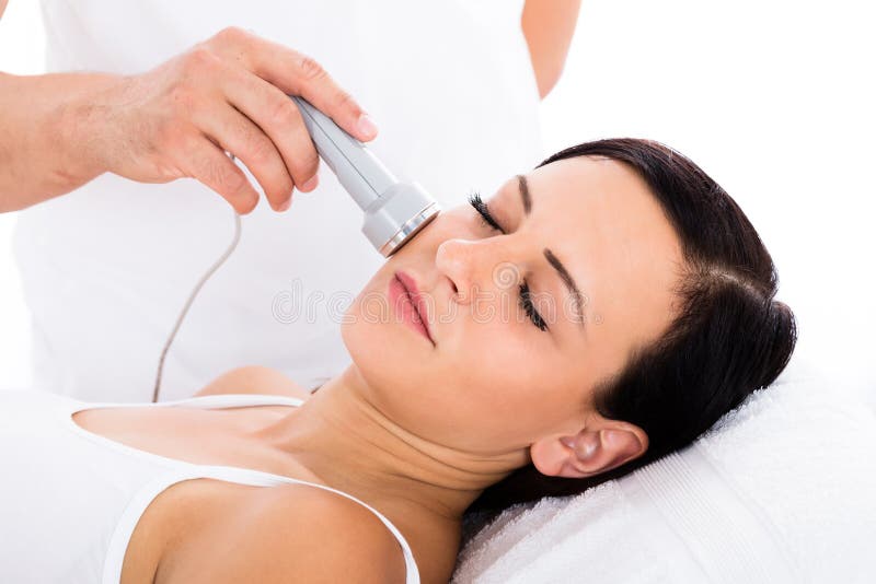 Mulher que recebe a terapia de Microdermabrasion na testa foto de stock Mulher que recebe a terapia de Microdermabrasion na testa foto de stock