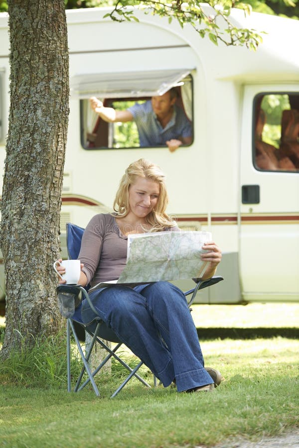Mulher que relaxa fora da roulotte em férias fotos de stock Mulher que relaxa fora da roulotte em férias fotos de stock