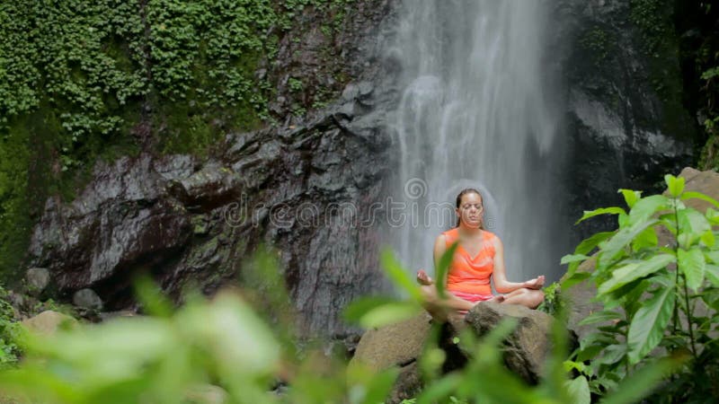 Mulher que senta-se na meditação