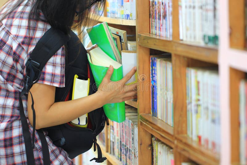 Mulher que tenta roubar livros na estante na sala da biblioteca, roubo patológico, cleptomania fotos de stock Mulher que tenta roubar livros na estante na sala da biblioteca, roubo patológico, cleptomania fotos de stock