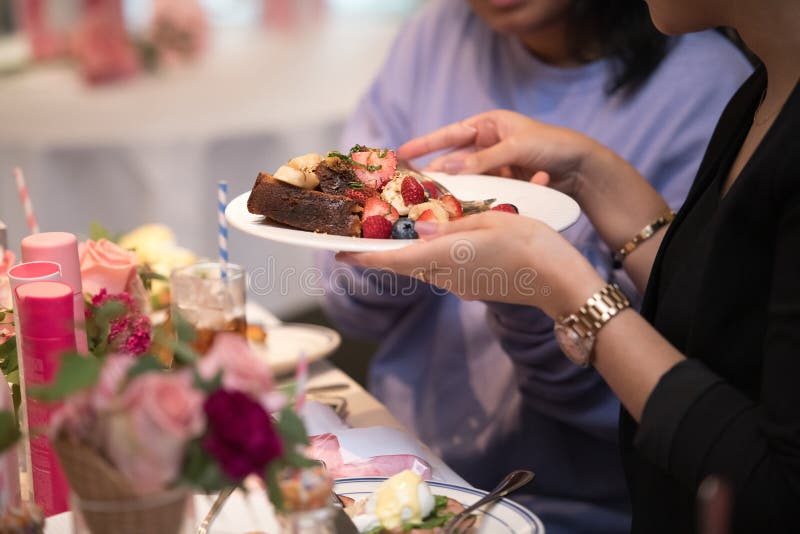 Mulher que toma o brinde com salada de fruto em um restaurante e que fala com seu amigo imagens de stock royalty free Mulher que toma o brinde com salada de fruto em um restaurante e que fala com seu amigo imagens de stock royalty free