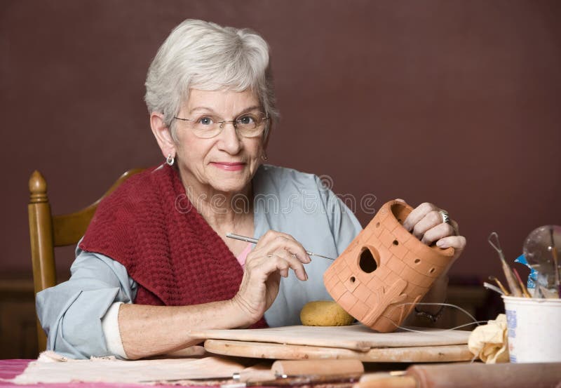 Senior woman working on a clay sculpture. Senior woman working on a clay sculpture