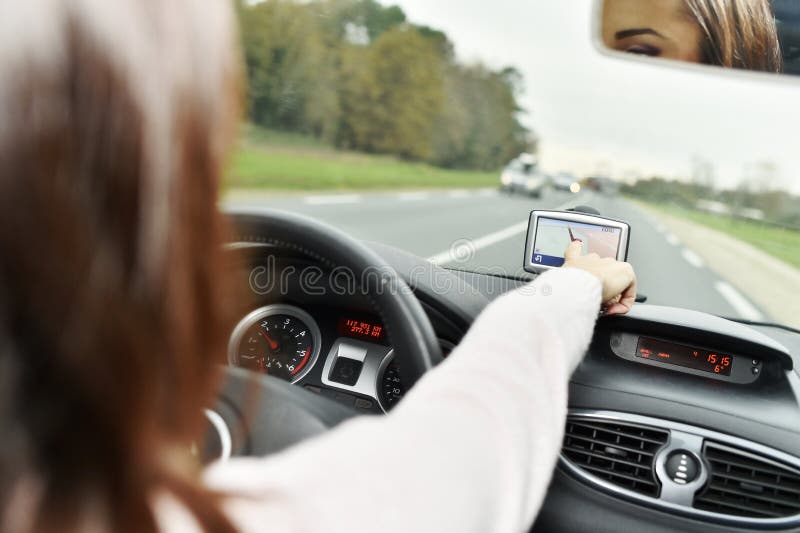 Mulher que verifica gps na estrada imagem de stock royalty free Mulher que verifica gps na estrada imagem de stock royalty free