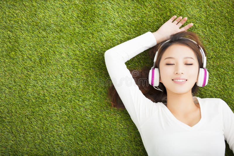Mulher relaxado que escuta a música com fones de ouvido