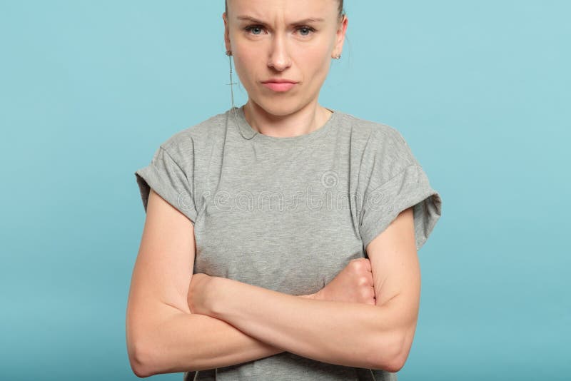 A mulher resistente irritada mal-humorada cruzou os braços emocionais fotografia de stock A mulher resistente irritada mal-humorada cruzou os braços emocionais fotografia de stock