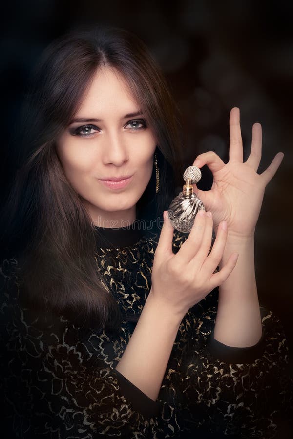 Mulher retro do encanto que guarda a garrafa de perfume do vintage fotos de stock Mulher retro do encanto que guarda a garrafa de perfume do vintage fotos de stock