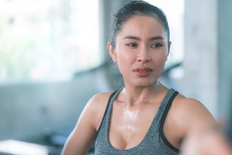 Mulher saudável está suando enquanto se exercita no ginásio da Fitness fotografia de stock royalty free Mulher saudável está suando enquanto se exercita no ginásio da Fitness fotografia de stock royalty free