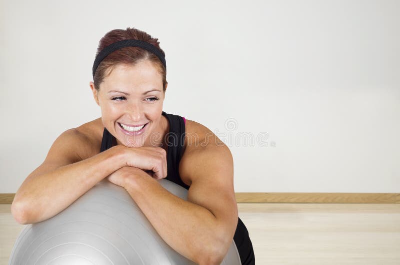 Mulher saudável feliz da aptidão que descansa em uma bola do exercício fotos de stock royalty free
