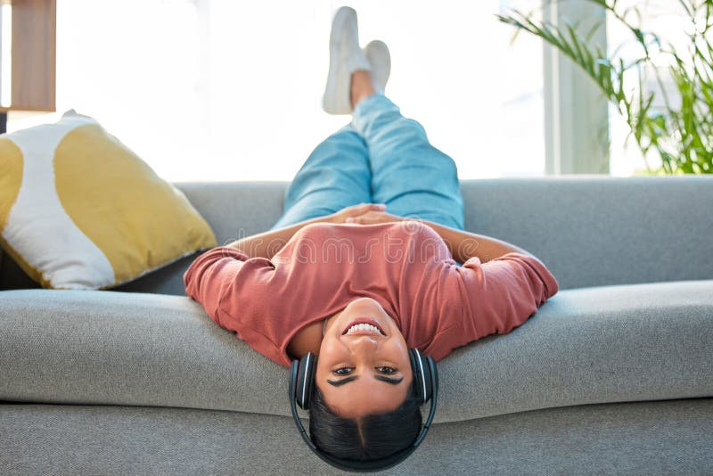 Garota feliz com telefone relaxa no sofá ou no sofá da sala