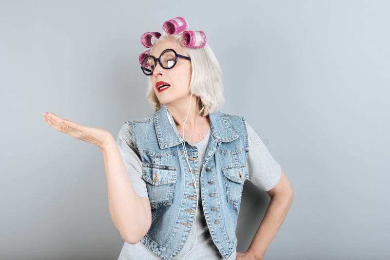 Mulher superior encantador que gesticula ao estar imagens de stock royalty free Mulher superior encantador que gesticula ao estar imagens de stock royalty free