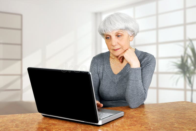 A mulher superior idosa elegante que usa o laptop comunica-se fotos de stock A mulher superior idosa elegante que usa o laptop comunica-se fotos de stock
