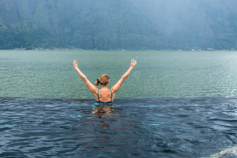 Mulher superior na piscina da natureza com fundo surpreendente da montanha Ilha tropical Bali, Indonésia fotografia de stock Mulher superior na piscina da natureza com fundo surpreendente da montanha Ilha tropical Bali, Indonésia fotografia de stock