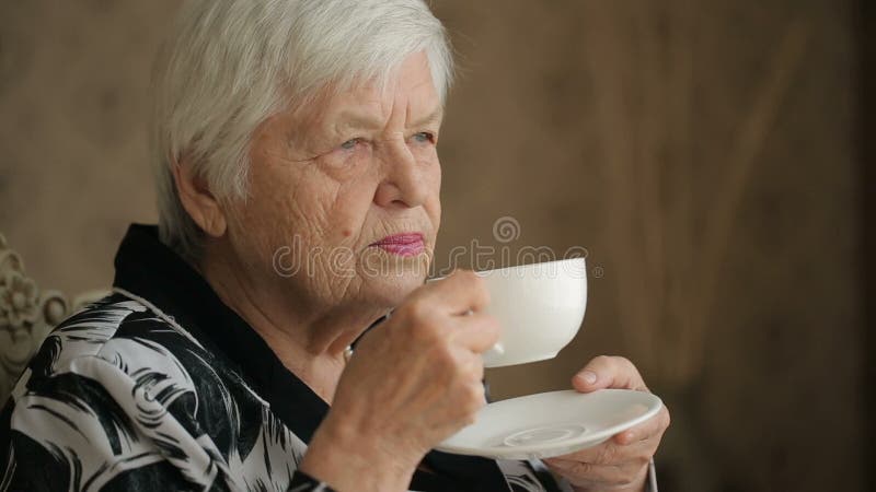 Mulher superior que aprecia um chá filme