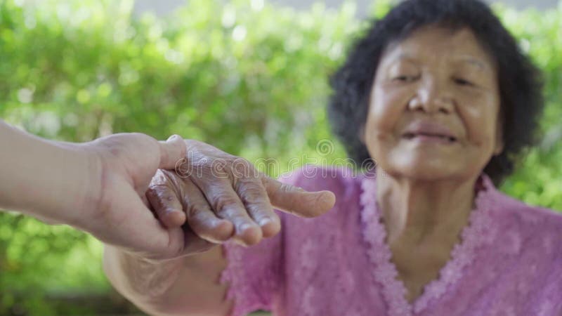 Mulher superior que guarda as mãos com mulher